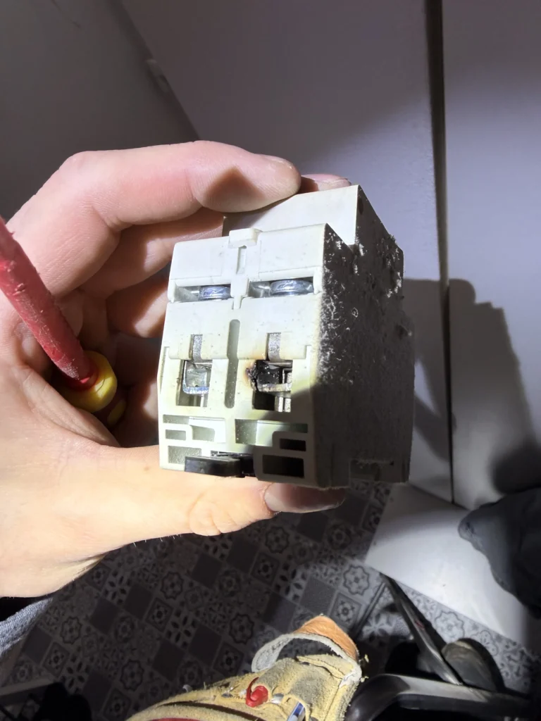 Égett biztosíték a régi biztosítéktáblában Biztosítéktábla csere villanyszerelő által Kismegszakító tábla felújítás Budapest Hibás olvadóbiztosíték cseréje